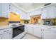 Kitchen with white cabinets, yellow backsplash, and pass-through to another room at 4242 Sheldon Pl, New Port Richey, FL 34652