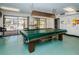 Recreation room featuring a covered pool table, and sliding glass doors to community pool at 4242 Sheldon Pl, New Port Richey, FL 34652