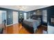 Bedroom with dark blue walls, hardwood floors, and decorated with Michigan collegiate decor at 4926 Cardinal Trl, Palm Harbor, FL 34683