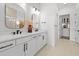 Bright bathroom featuring a double vanity, modern fixtures, and neutral decor at 4951 Ribbon Rock Cv, Lakewood Ranch, FL 34211