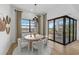 Modern dining area with stylish chairs, large window views, and access to outdoor patio at 4951 Ribbon Rock Cv, Lakewood Ranch, FL 34211