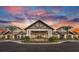 Grand community center exterior view under a vibrant sky at sunset featuring professional landscaping at 4951 Ribbon Rock Cv, Lakewood Ranch, FL 34211