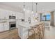 Bright kitchen with large island, modern lighting, stainless steel appliances, and view to dining area at 4951 Ribbon Rock Cv, Lakewood Ranch, FL 34211
