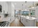 Open concept kitchen showcases a large island, modern appliances, and views into a living area at 4951 Ribbon Rock Cv, Lakewood Ranch, FL 34211