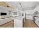 Modern open kitchen with a center island, pendant lighting, and view of a living space at 4951 Ribbon Rock Cv, Lakewood Ranch, FL 34211
