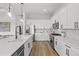 Modern kitchen features white cabinetry, stainless steel appliances, a large island, and pendant lighting at 4951 Ribbon Rock Cv, Lakewood Ranch, FL 34211