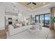 Bright living room boasts a ceiling fan, white sofa, hardwood floors, and kitchen access at 4951 Ribbon Rock Cv, Lakewood Ranch, FL 34211