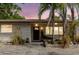 Inviting front entrance with a decorative wooden bench, mature landscaping, and stylish brick walkway at 549 E Center St, Tarpon Springs, FL 34689
