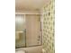 Compact bathroom with vintage green wallpaper and a bathtub-shower combination at 6020 Shore S Blvd # 903, Gulfport, FL 33707