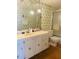 Retro bathroom featuring a vanity, decorative wallpaper, and a combined shower and tub at 6020 Shore S Blvd # 903, Gulfport, FL 33707