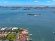 Waterfront home featuring a backyard pool, private boat dock, lush landscaping, and bay views in a coastal community at 6130 Kipps Colony W Dr, Gulfport, FL 33707