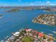 Waterfront home featuring a backyard pool, private boat dock, lush landscaping, and bay views in a coastal community at 6130 Kipps Colony W Dr, Gulfport, FL 33707