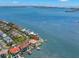 Waterfront home featuring a backyard pool, private boat dock, lush landscaping, and bay views in a coastal community at 6130 Kipps Colony W Dr, Gulfport, FL 33707