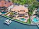 Waterfront home featuring a backyard pool, patio, private boat dock, lush landscaping, and bay views from multiple levels at 6130 Kipps Colony W Dr, Gulfport, FL 33707