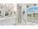 Spacious bathroom featuring peacock accents, a glass shower, double sink vanity, and private balcony at 6130 Kipps Colony W Dr, Gulfport, FL 33707