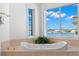 Tranquil bathtub with lush greenery and expansive windows overlooking the serene waterfront views at 6130 Kipps Colony W Dr, Gulfport, FL 33707