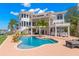 Luxury home boasts a waterfront pool, outdoor bar, lush landscaping, and multiple balconies at 6130 Kipps Colony W Dr, Gulfport, FL 33707