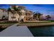 Waterfront home with private dock, pool, and lush landscaping at dusk at 6130 Kipps Colony W Dr, Gulfport, FL 33707
