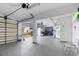 Large open garage space with epoxy floors, shelving, and access to outdoor patio at 6130 Kipps Colony W Dr, Gulfport, FL 33707