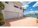 Exterior view shows a spacious three-car garage with a paver driveway, plus access to the dock and waterfront at 6130 Kipps Colony W Dr, Gulfport, FL 33707