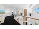 Hallway with white railings, a fireplace view, and large windows at 6130 Kipps Colony W Dr, Gulfport, FL 33707