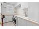 Well-lit laundry room with white cabinetry, countertops, sink, and a washer and dryer at 6130 Kipps Colony W Dr, Gulfport, FL 33707