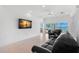 Spacious living room featuring a large TV and comfortable black leather sofa at 6130 Kipps Colony W Dr, Gulfport, FL 33707