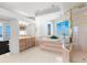Spacious main bathroom featuring a tub, glass shower, double vanity, and a large window offering beautiful water views at 6130 Kipps Colony W Dr, Gulfport, FL 33707
