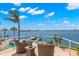 Balcony with seating area, offering panoramic views of the bay and a glimpse of the pool at 6130 Kipps Colony W Dr, Gulfport, FL 33707