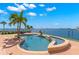 Stunning waterfront pool with a tanning ledge, lush landscaping, and picturesque views at 6130 Kipps Colony W Dr, Gulfport, FL 33707