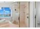Bathroom featuring an enclosed shower with gold fixtures, window views, and tiled walls at 6130 Kipps Colony W Dr, Gulfport, FL 33707