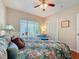 Cozy bedroom featuring a bright window with blinds, a ceiling fan and a closet at 631 Baynard Dr, Tarpon Springs, FL 34689