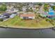 Aerial view of the waterfront property with lush lawn, patio, and canal access with mature landscaping at 6357 Spanish Main Dr, Apollo Beach, FL 33572
