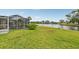 Large grassy backyard with views of the canal and a screened-in patio at 6357 Spanish Main Dr, Apollo Beach, FL 33572