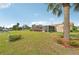 Lush backyard featuring a manicured lawn, screened patio, and partial water views at 6357 Spanish Main Dr, Apollo Beach, FL 33572