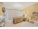 Cozy bedroom featuring a stylish chandelier, a plush bed, and ample natural light at 6357 Spanish Main Dr, Apollo Beach, FL 33572