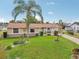 Well-maintained single-Gathering home featuring a green lawn, palm tree and white picket fence at 6357 Spanish Main Dr, Apollo Beach, FL 33572