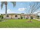 Well-maintained front yard with lush green grass, mature trees, and a charming one story home at 6357 Spanish Main Dr, Apollo Beach, FL 33572