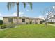 Well-manicured front yard with lush green grass and nicely placed landscaping with a palm tree for curb appeal at 6357 Spanish Main Dr, Apollo Beach, FL 33572