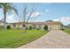 Charming single-story home with a well-manicured lawn, brick driveway and inviting curb appeal at 6357 Spanish Main Dr, Apollo Beach, FL 33572