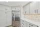 Contemporary kitchen featuring modern stainless steel refrigerator and elegant cabinetry at 6357 Spanish Main Dr, Apollo Beach, FL 33572
