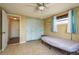Cozy bedroom featuring tiled flooring, ceiling fan, closet, and natural light from the window at 6831 Greenwich Ave, New Port Richey, FL 34653