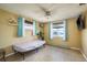 Bright bedroom showcasing tiled floor, a ceiling fan, natural lighting, and simple furnishings at 6831 Greenwich Ave, New Port Richey, FL 34653