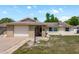 Inviting home with brick accents, an attached garage, and a well-maintained lawn at 6831 Greenwich Ave, New Port Richey, FL 34653