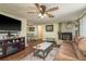 Comfortable living room with a brick fireplace, ceiling fan, and an open layout at 6831 Greenwich Ave, New Port Richey, FL 34653