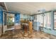 Enclosed sunroom featuring tiled floor, bar, refrigerator, and ample natural light from multiple windows at 6831 Greenwich Ave, New Port Richey, FL 34653