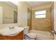 Tiled bathroom with window, and combined tub and shower at 7338 Coventry Dr, Port Richey, FL 34668