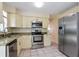 Bright kitchen featuring stainless steel appliances, granite countertops, and ample cabinetry at 7338 Coventry Dr, Port Richey, FL 34668