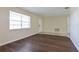 Bright living room featuring wood floors and a large window providing natural light at 7338 Coventry Dr, Port Richey, FL 34668