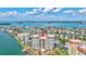 Panoramic aerial view of waterfront condominiums with a pool, tennis courts, and boat docks in a coastal community at 736 Island Way # 303, Clearwater Beach, FL 33767